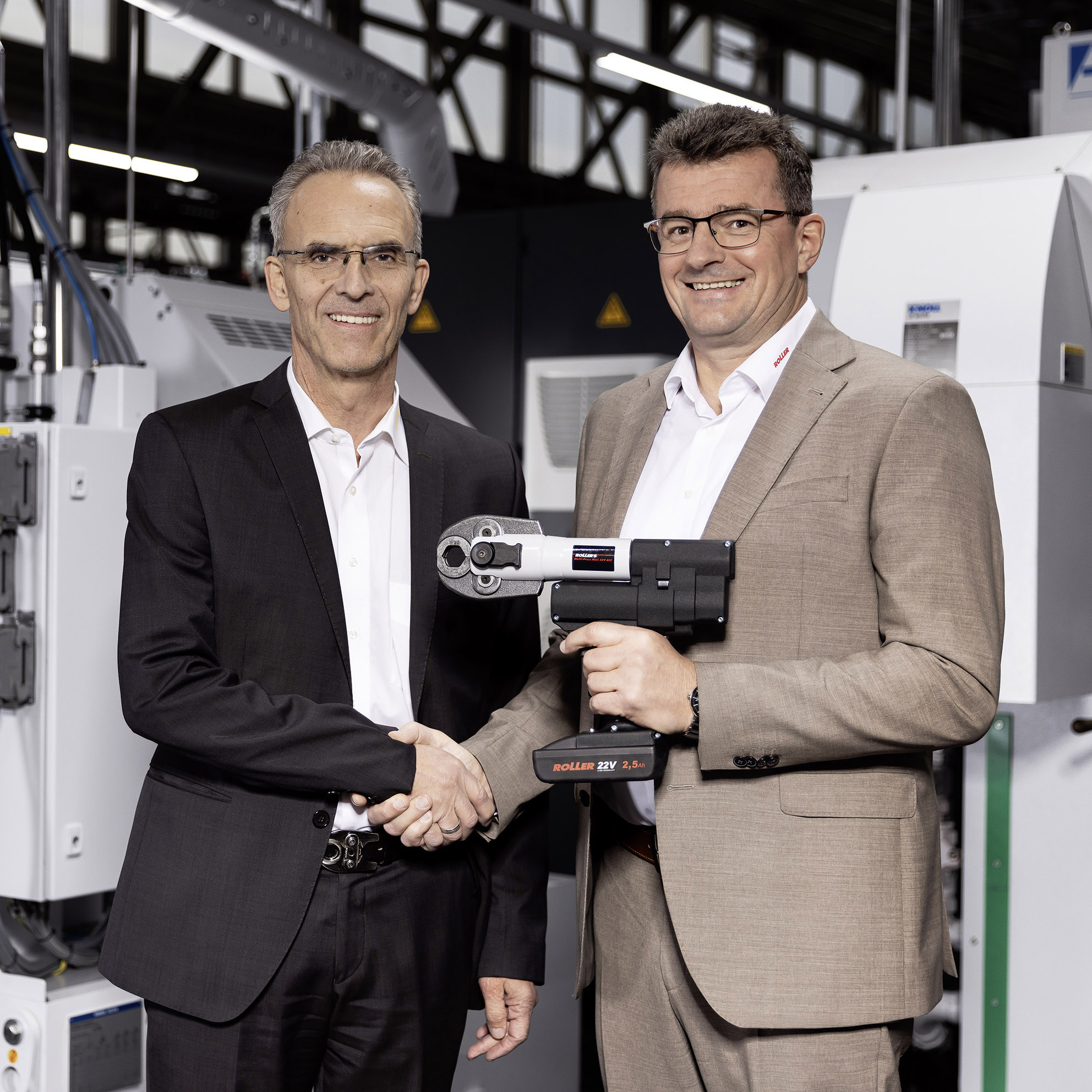 symbolische Übergabe einer ROLLER’S Akku-Radialpresse durch Rainer Hech (Geschäftsführer Albert Roller GmbH & Co KG) an Hans Seeger (Verkaufsdirektor und Prokurist der REMS GmbH & Co KG)